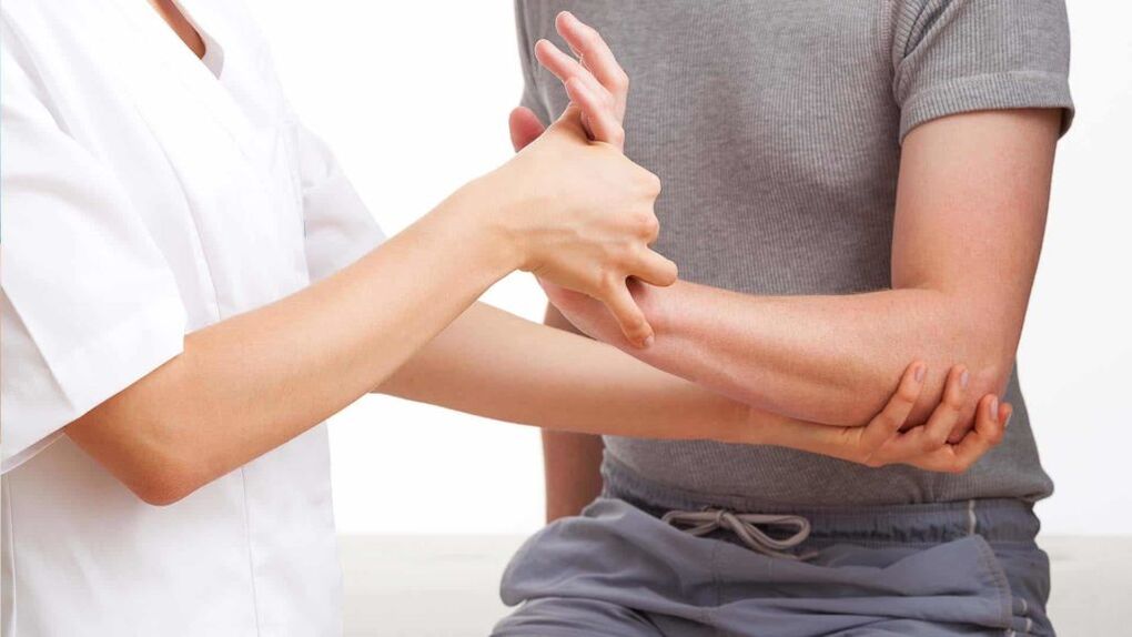 lékař zkoumá ruku s artritidou